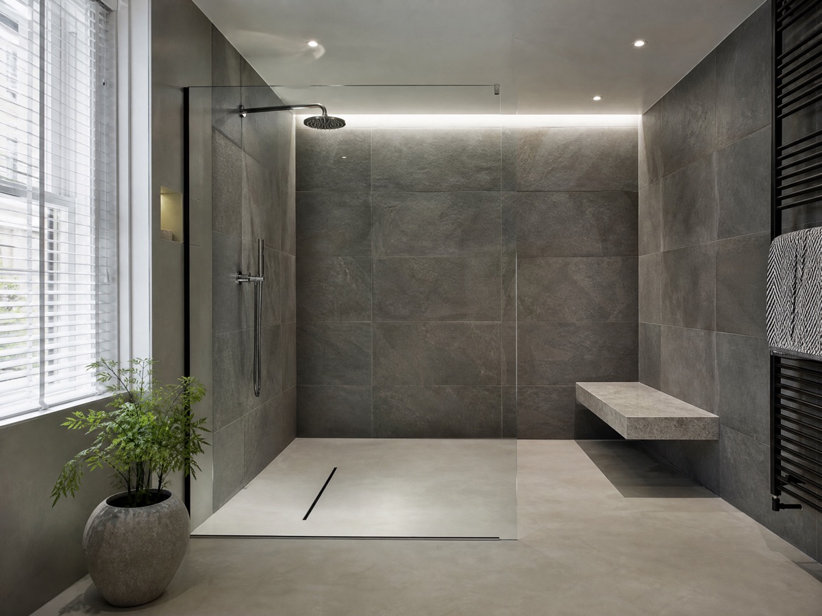 Concept image of a contemporary wet room with a linear drain and glass panel